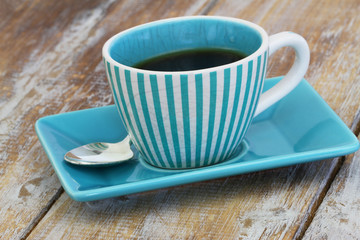 Black coffee in vintage coffee cup on rustic surface
