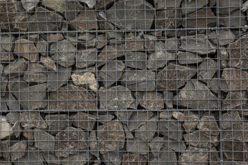 Stone wall behind mesh frame.