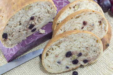 Fruit bread with aronia sliced on a wooden plate with dried aron