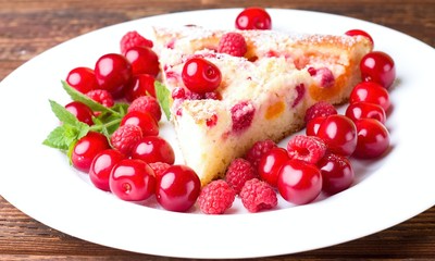Detail of single portion of fruit pie with berries around