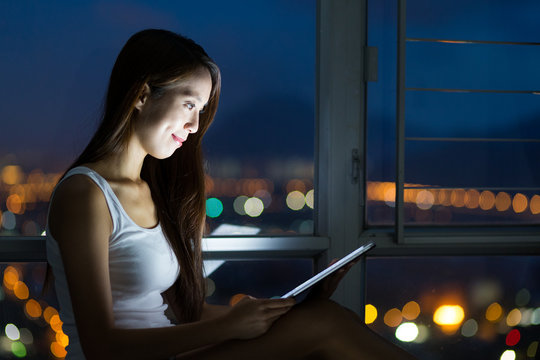 Woman using the tablet pc at night