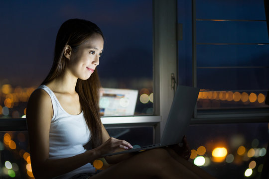 Young woman use of the notebook computer at night