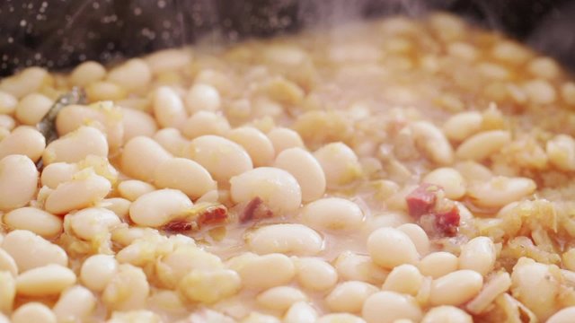HD 1080 static: white beans freshly cooked poured into casserole dish; close up