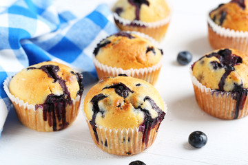 Tasty blueberry muffins on a blue wooden background