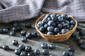 Blueberries in basket on a blue wooden background
