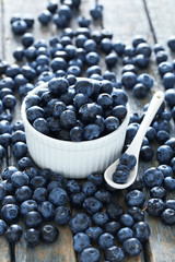 Blueberries in bowl on a blue wooden background