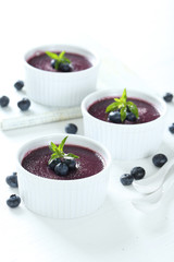 Delicious blueberry mousse in bowls on wooden table