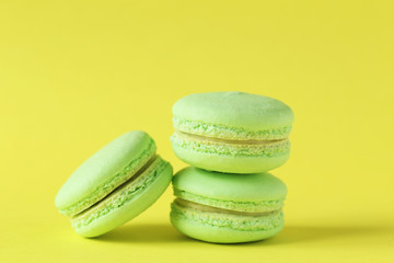 Green macarons on yellow paper background
