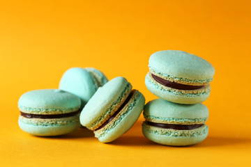 Tasty macarons on orange paper background