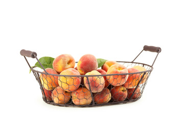Fresh peach fruit in basket on a white background