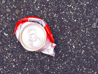 Zerdrückte Blechdose auf Asphalt