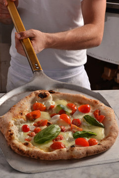 Cocinero horneando tradicional pizza italiana.