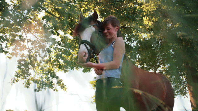 Teen girl giving horse a treat