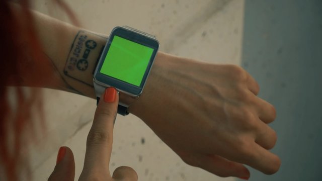 Woman using his green screened smart watch