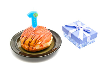 donut with one years birthday candle and gift