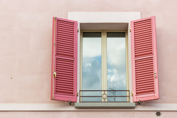 Fototapeta premium Iron grating window with red shutters