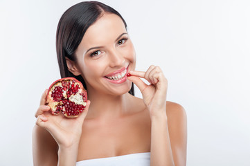 Pretty young girl is tasting fresh fruit