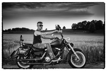 Fototapeta na wymiar Tough guy with his bike in front of a corn field