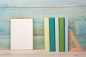 Back to school. Stack of colorful books on blue wooden background