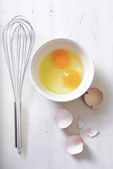 Cooking concept with eggs and whisk.