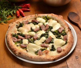 Pizza con salchicha en ambiente rustico.
