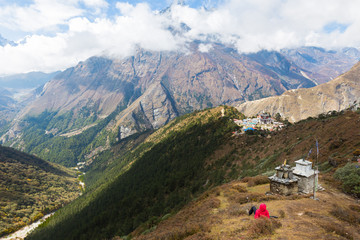 Woman rear view lying above Tengboche village buddhist monastery