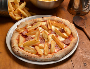Pizza con patatas en ambiente rustico.