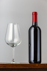 empty wine glass and red wine bottle - table