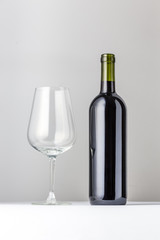 empty wine glass and red wine bottle - white