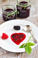 Homemade blackberry and raspberry jam in jars and fresh berries, selective focus