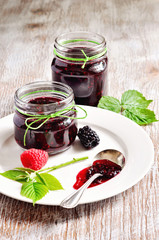 Homemade blackberry and raspberry jam in jars and fresh berries, selective focus