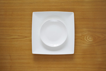 Empty porcelain plate on a wooden table top
