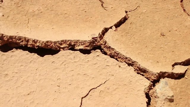 DROUGHT & DESERT - Dolly horizontally across hot and dry cracked parched earth. Camera Dolly Across Dry Cracked Earth, which is now without Water.  Shot covers different cracks than other versions