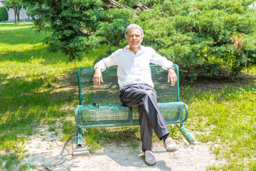 Old reassuring man resting on a bench