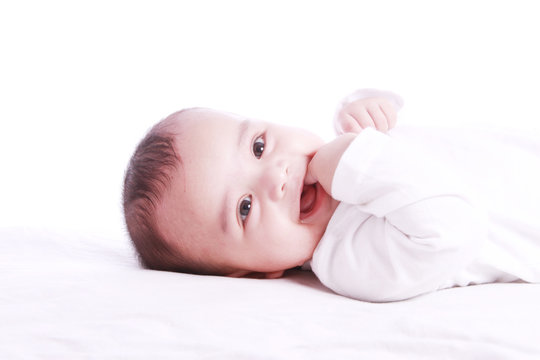 Happy cute baby eating finger , photographed against white background