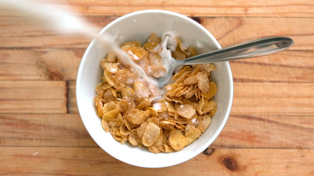 Milk pouring into bowl of cereal 