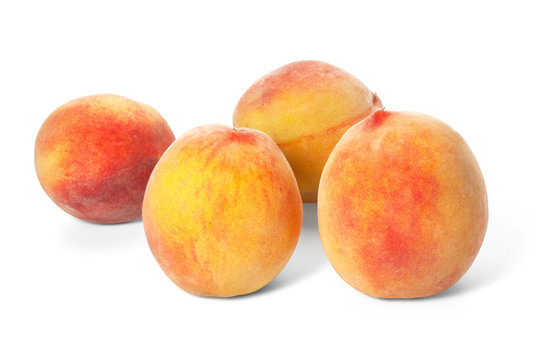 Four ripe peaches on a white background