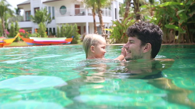 father learns swim daughter in swimming pool