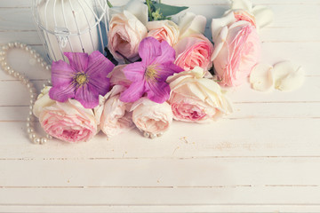 Pink roses  and violet clematis flowers and candle