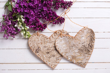 Fresh white and violet lilac flowers and two rustic hearts