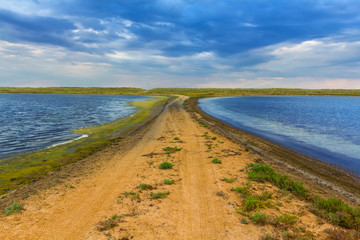 sandy dam between lakes
