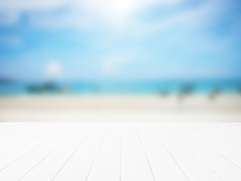 White wood floor with blurred sea background.