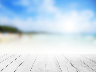 White wood floor with blurred ocean beach background.