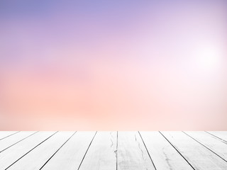 White wood floor with blurred sunlight sky background