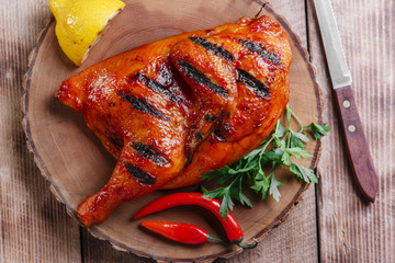 Grilled  half chicken barbecue on a wooden surface