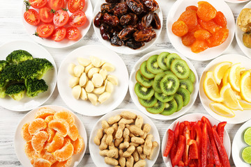 Different products on saucers on wooden table, top view