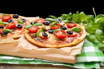Tasty pizza with vegetables and basil on table close up