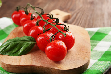 Fresh cherry tomatoes on wooden table, closeup