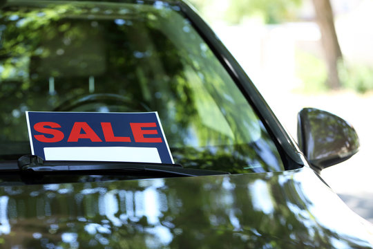 For Sale Sign On Windshield Of Car.