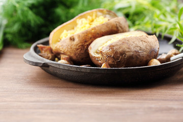 Baked potatoes with cheese and mushrooms on table close up